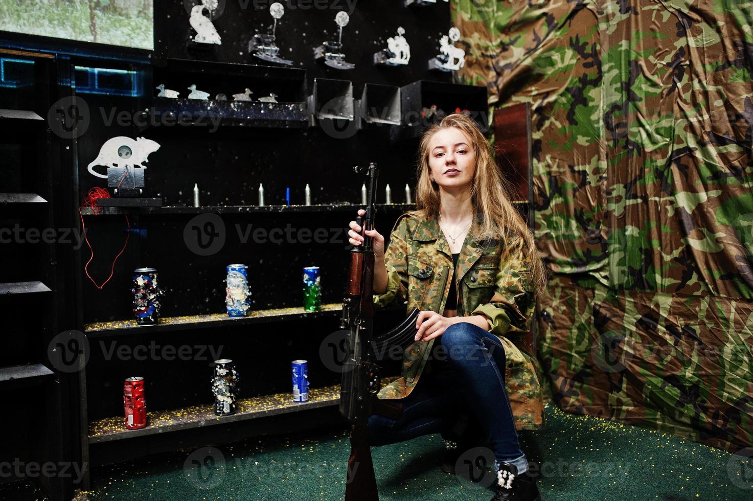 Girl with machine gun at hands on shooting range. photo