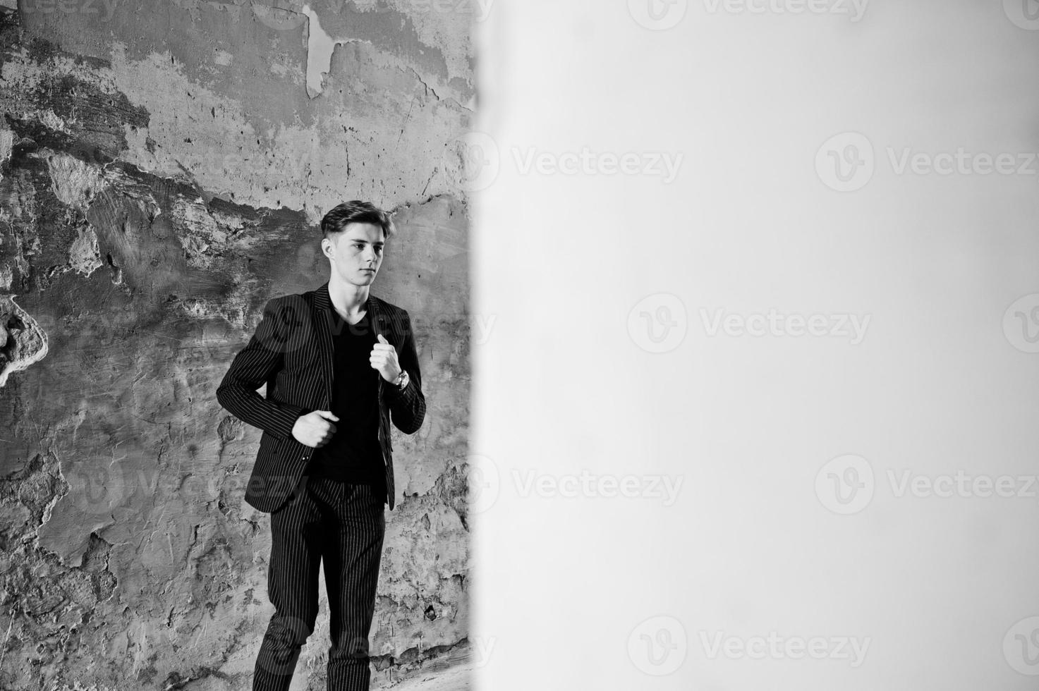 Young stylish macho boy in black jacket posed outdoor of street. Amazing model man. photo