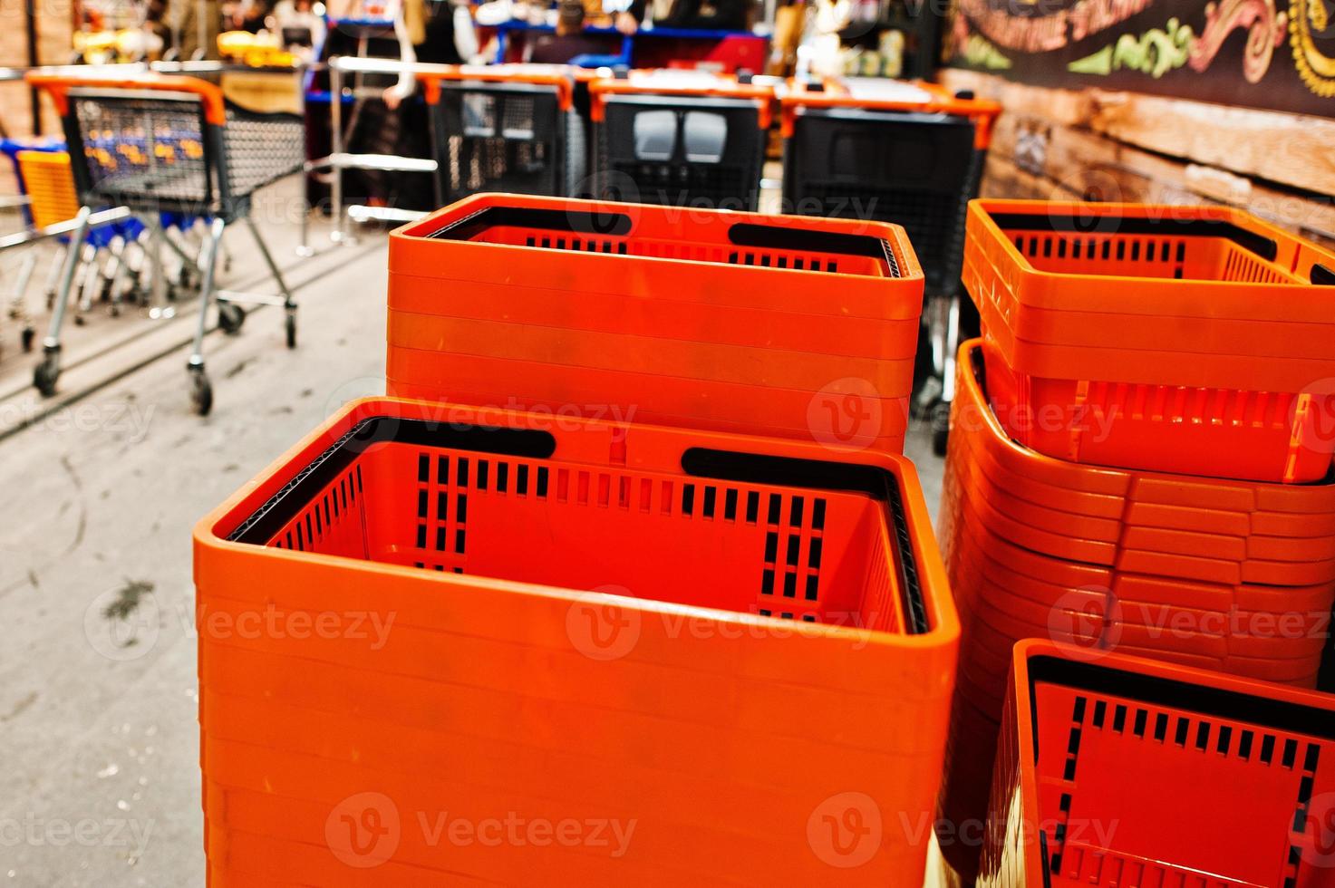 Orange plastic shopping baskets on supermarket. photo