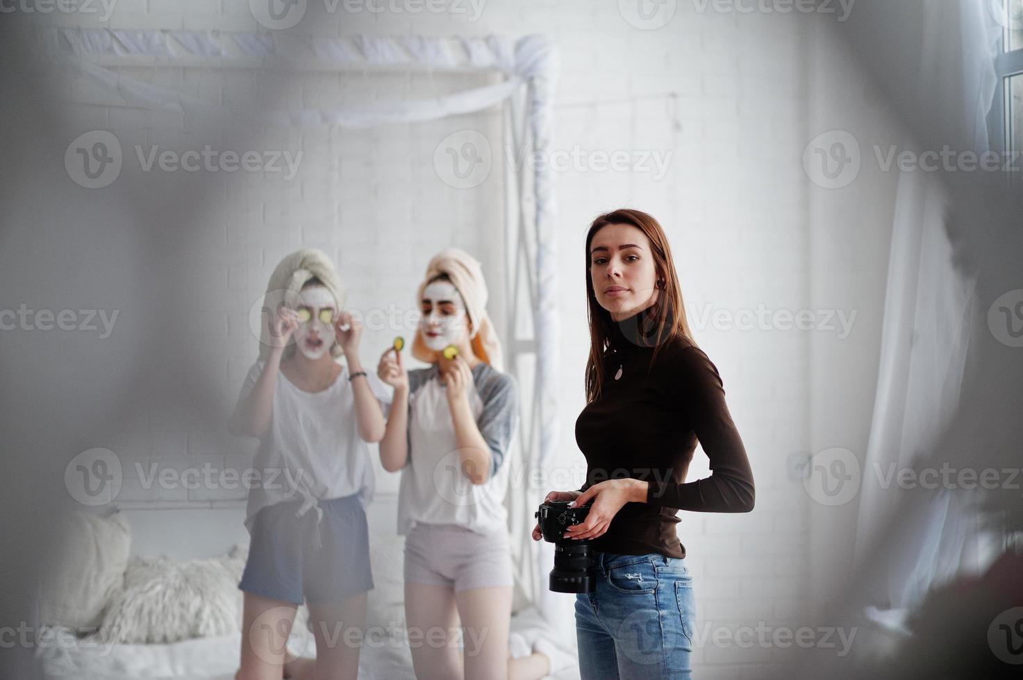 Young girl photographer shooting on studio two girls while they make their own masks cream . Professional photographer on work. photo