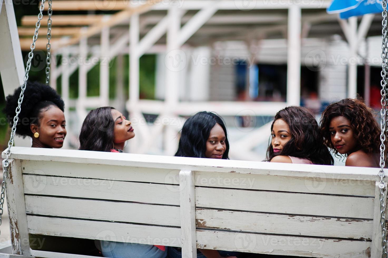 grupo de cinco chicas afroamericanas relajándose en un hermoso columpio. foto