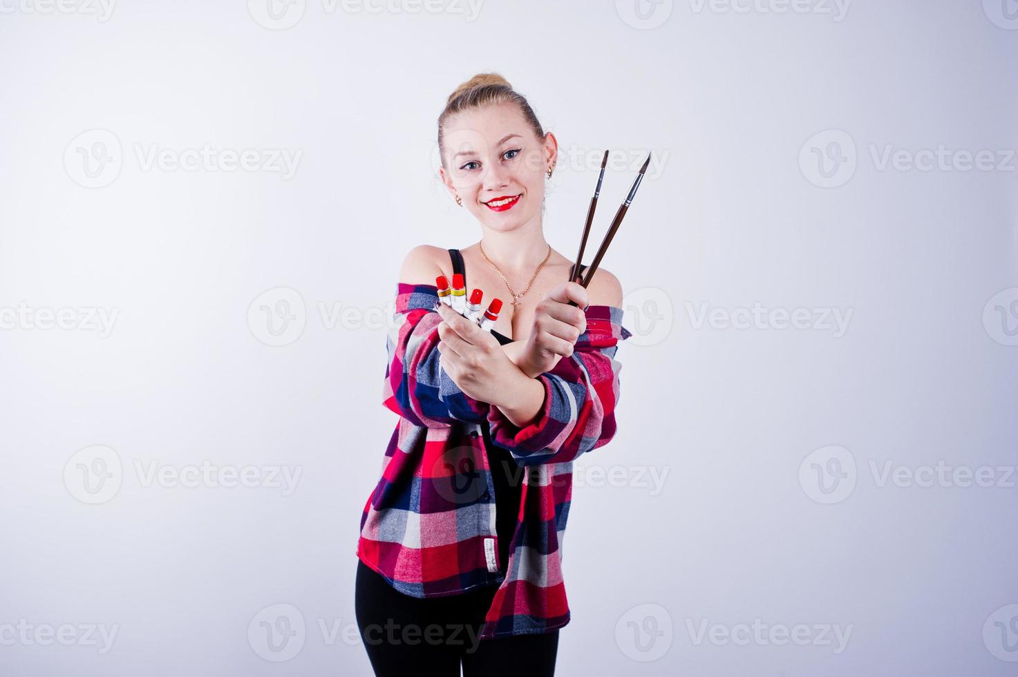 Beautiful woman artist painter with brushes posing in studio isolated on white. photo