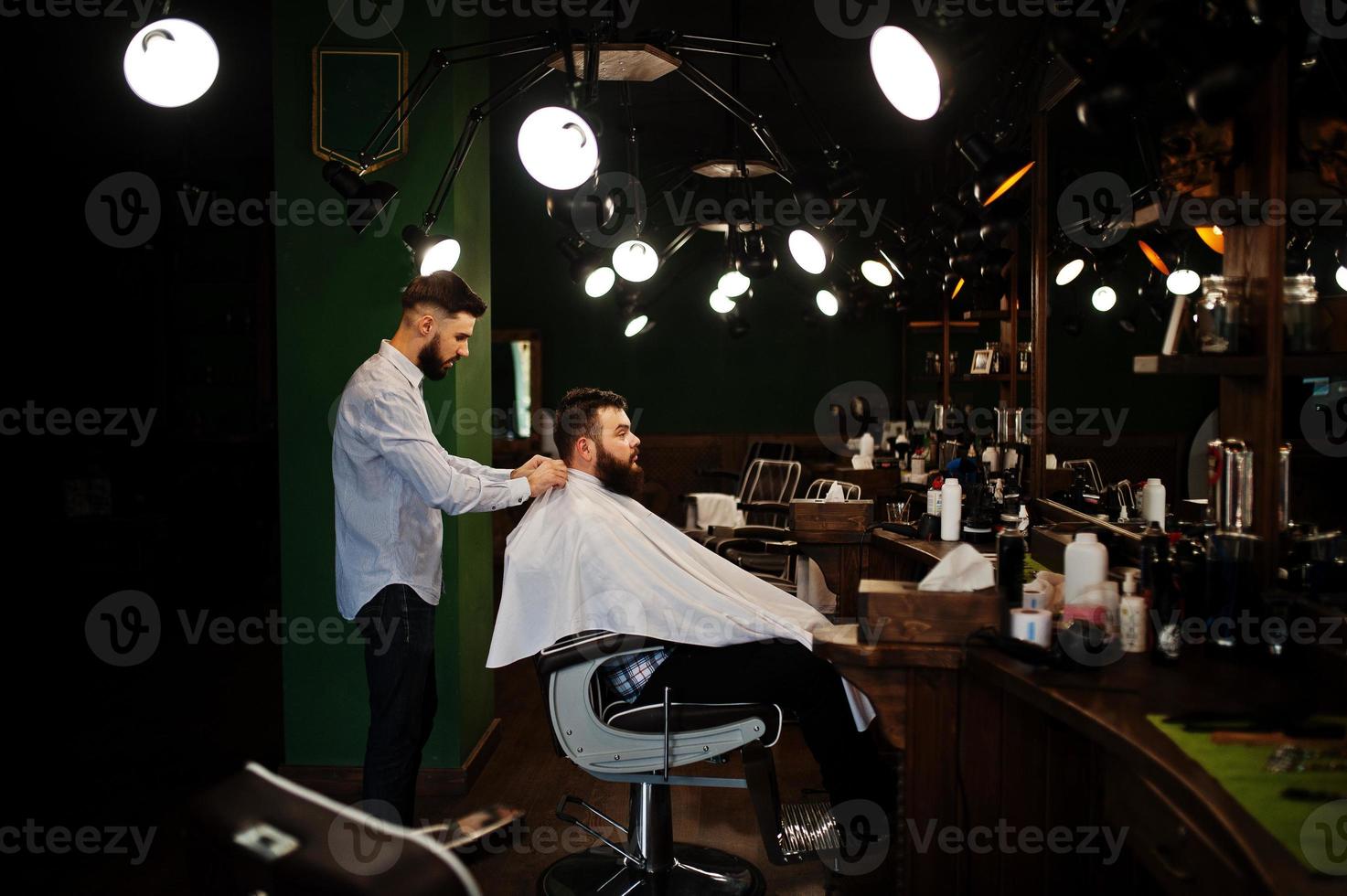 Handsome bearded man at the barbershop, barber at work. photo