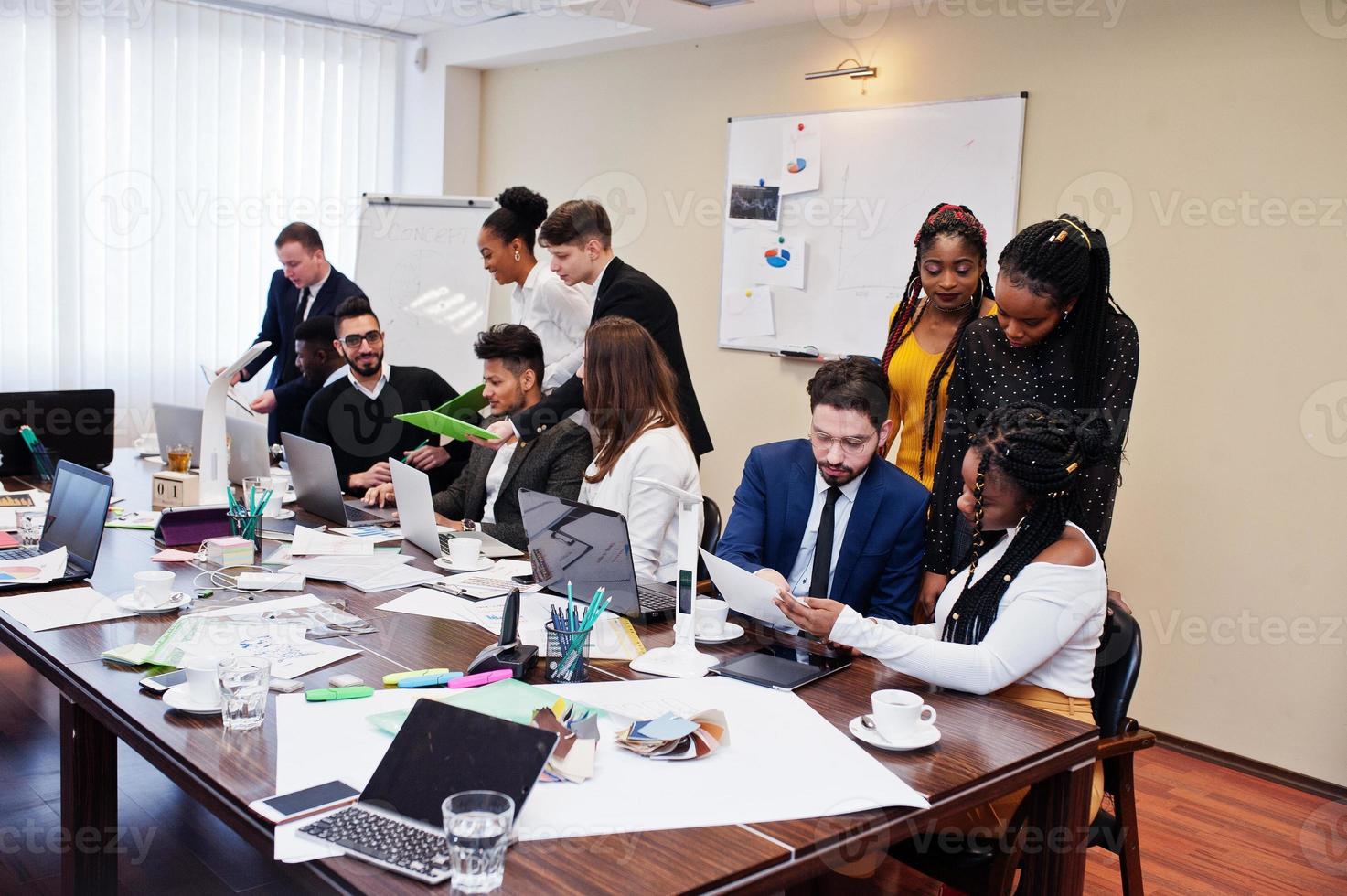 Multiracial young creative people in modern office. Group of young business people are working together with laptop, tablet. Successful freelancers team in coworking. photo
