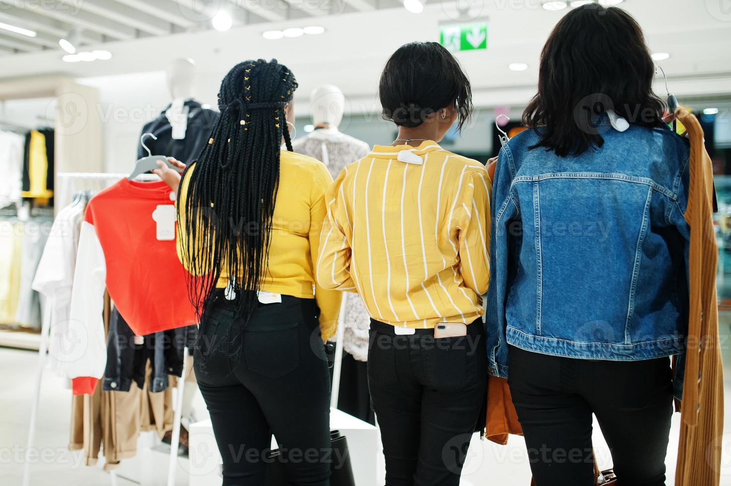 Back of three african woman choosing clothes at store. Shopping day. photo