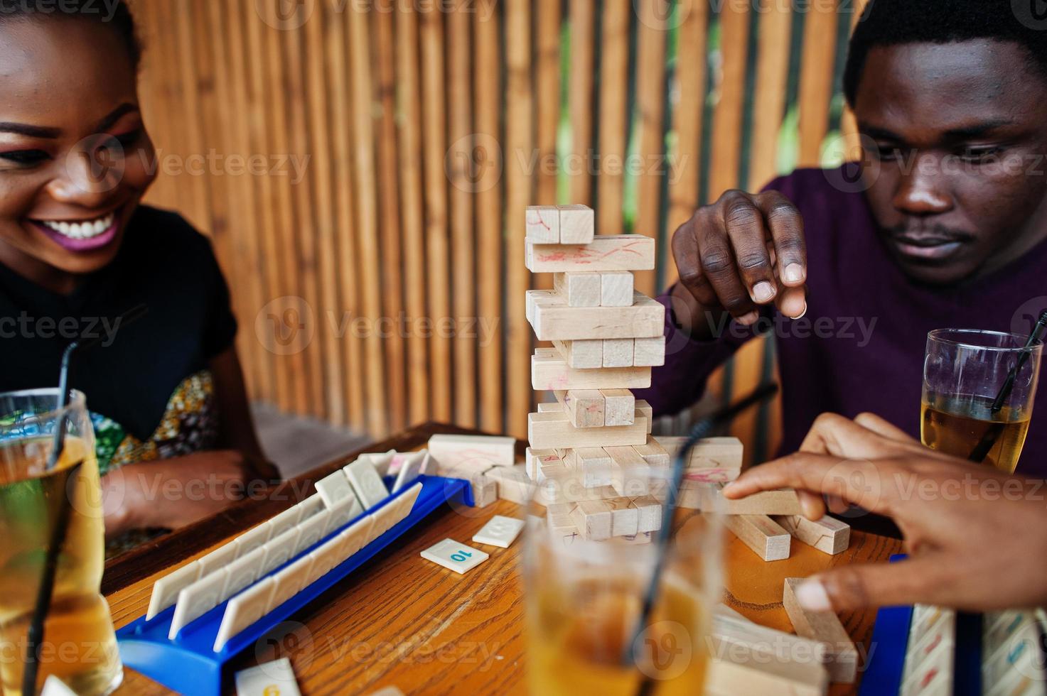 Group of three african american friends play table games. photo