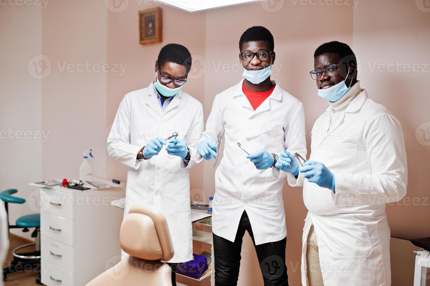 tres colegas médicos afroamericanos con herramientas a mano en la clínica. foto