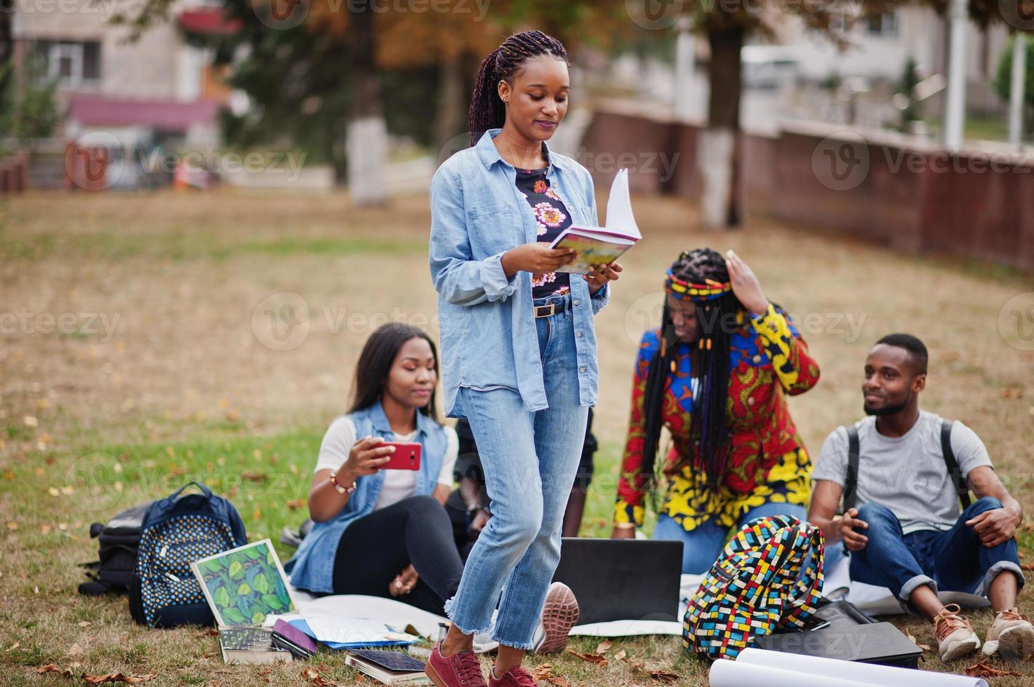 grupo de cinco estudiantes universitarios africanos que pasan tiempo juntos en el campus en el patio de la universidad. amigos negros afro estudiando. tema de la educación foto