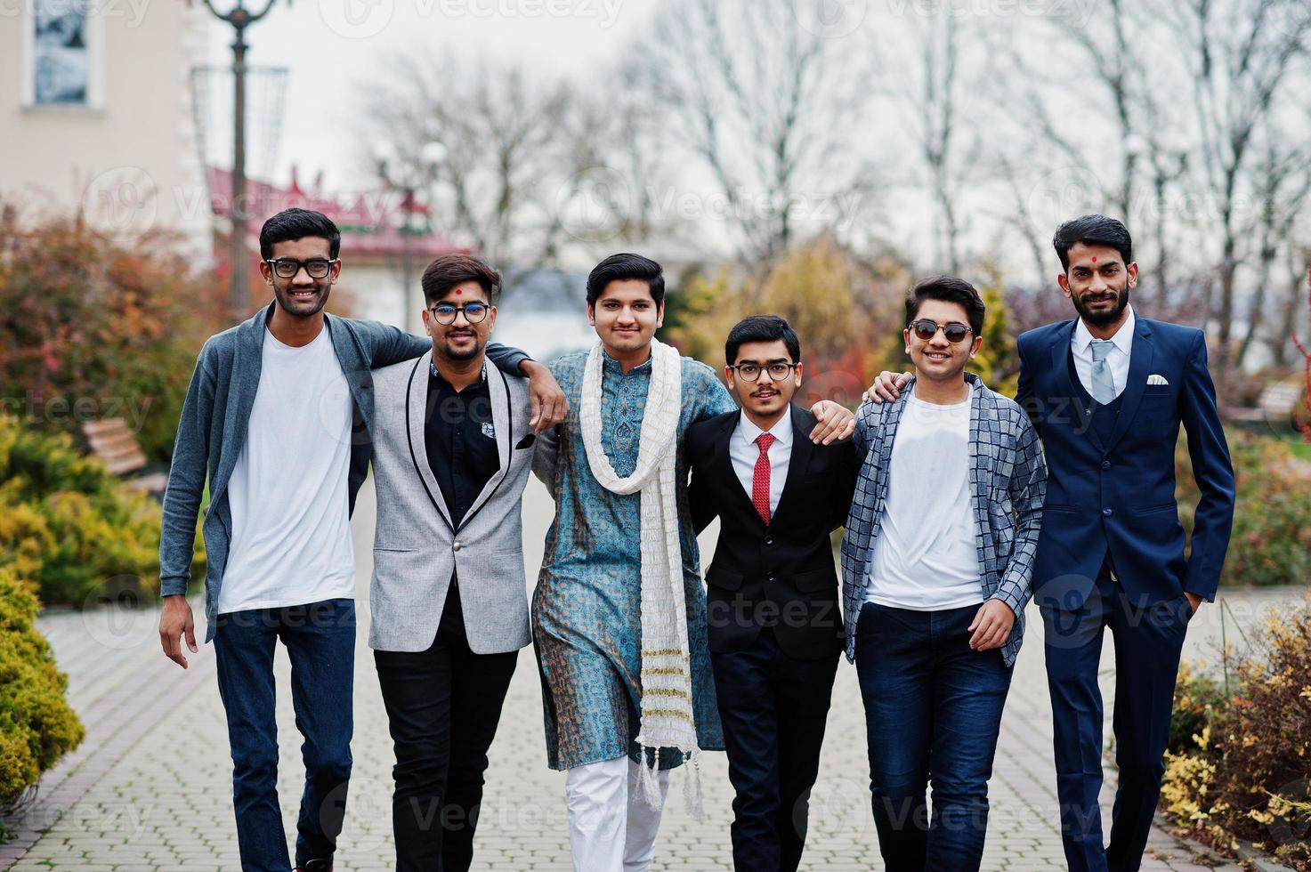 grupo de seis hombres indios del sur de asia en ropa tradicional, informal y de negocios caminando. foto