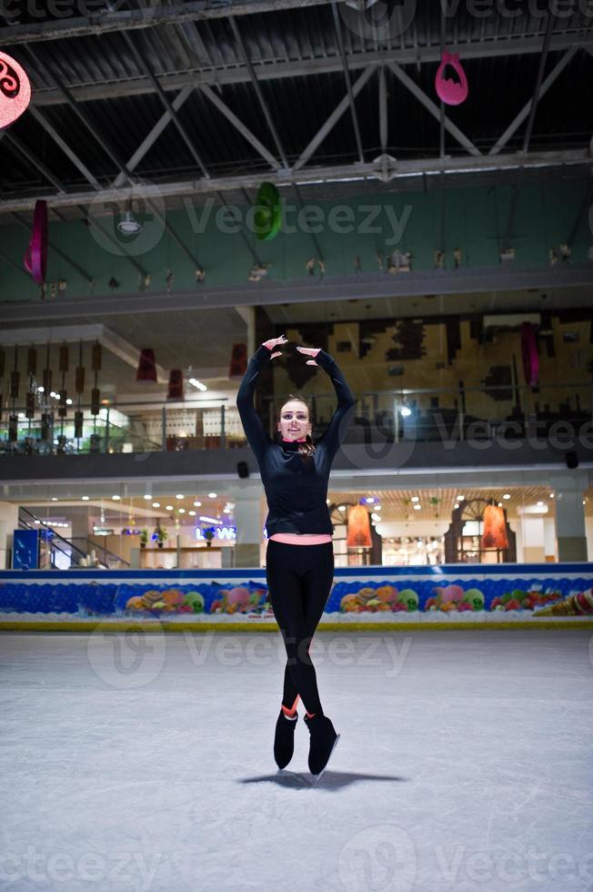 Figure skater woman at ice skating rink. photo