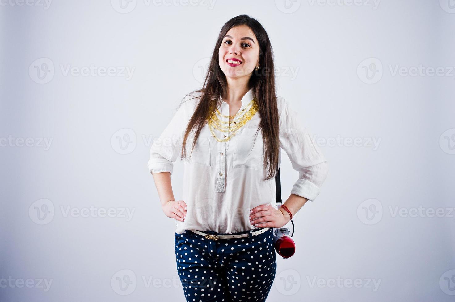 retrato de una mujer joven con pantalones azules y blusa blanca posando con megáfono en el estudio. foto