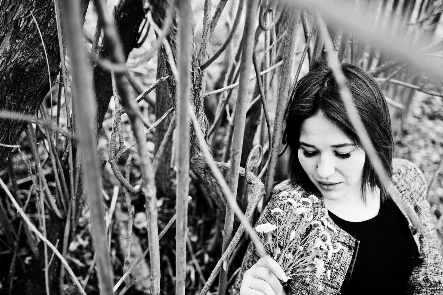 retrato de una chica morena vestida de negro en madera de primavera. foto