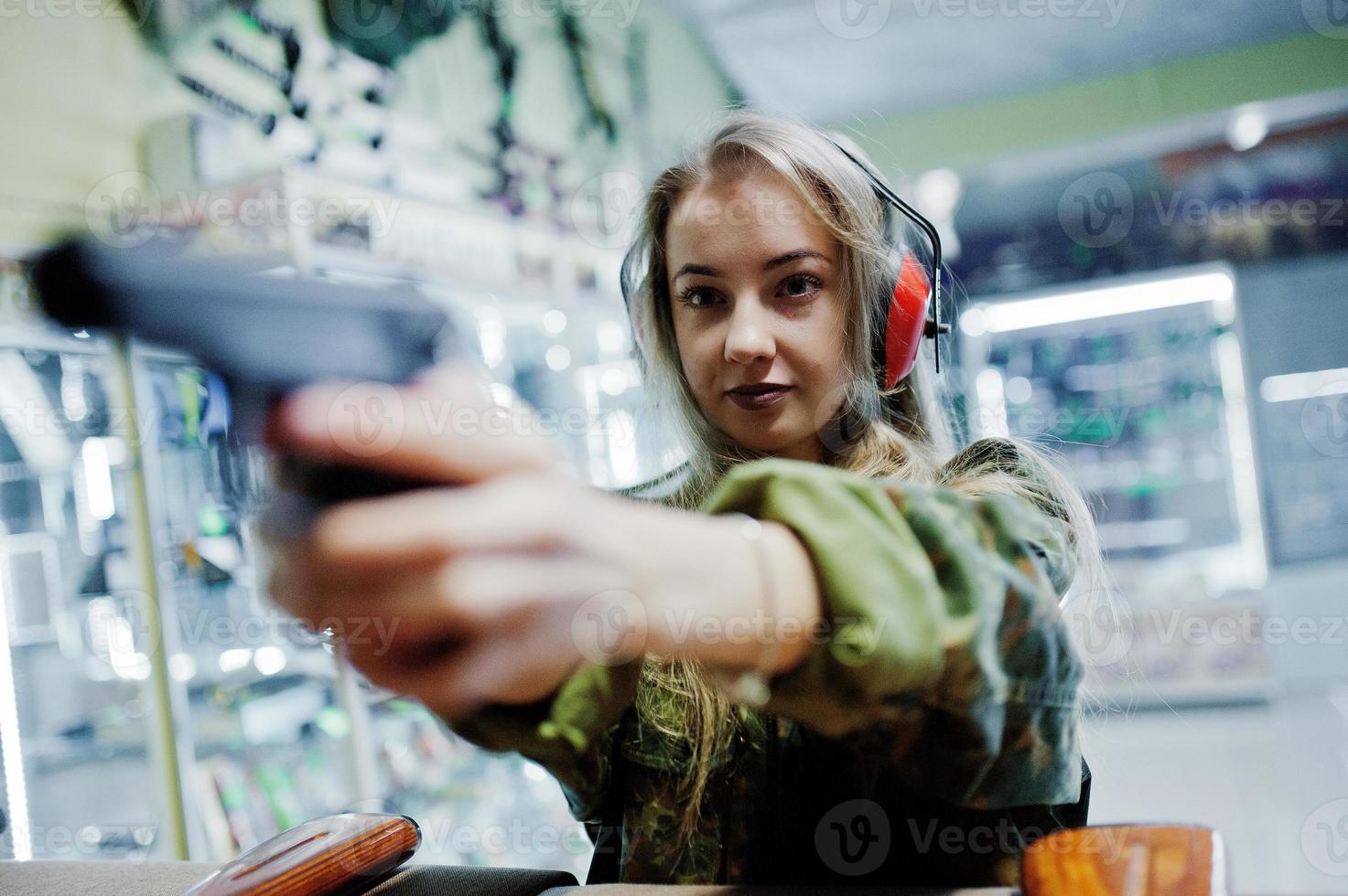 Disparando al campo de tiro. La mujer en el campo de tiro disparó con una pistola. foto