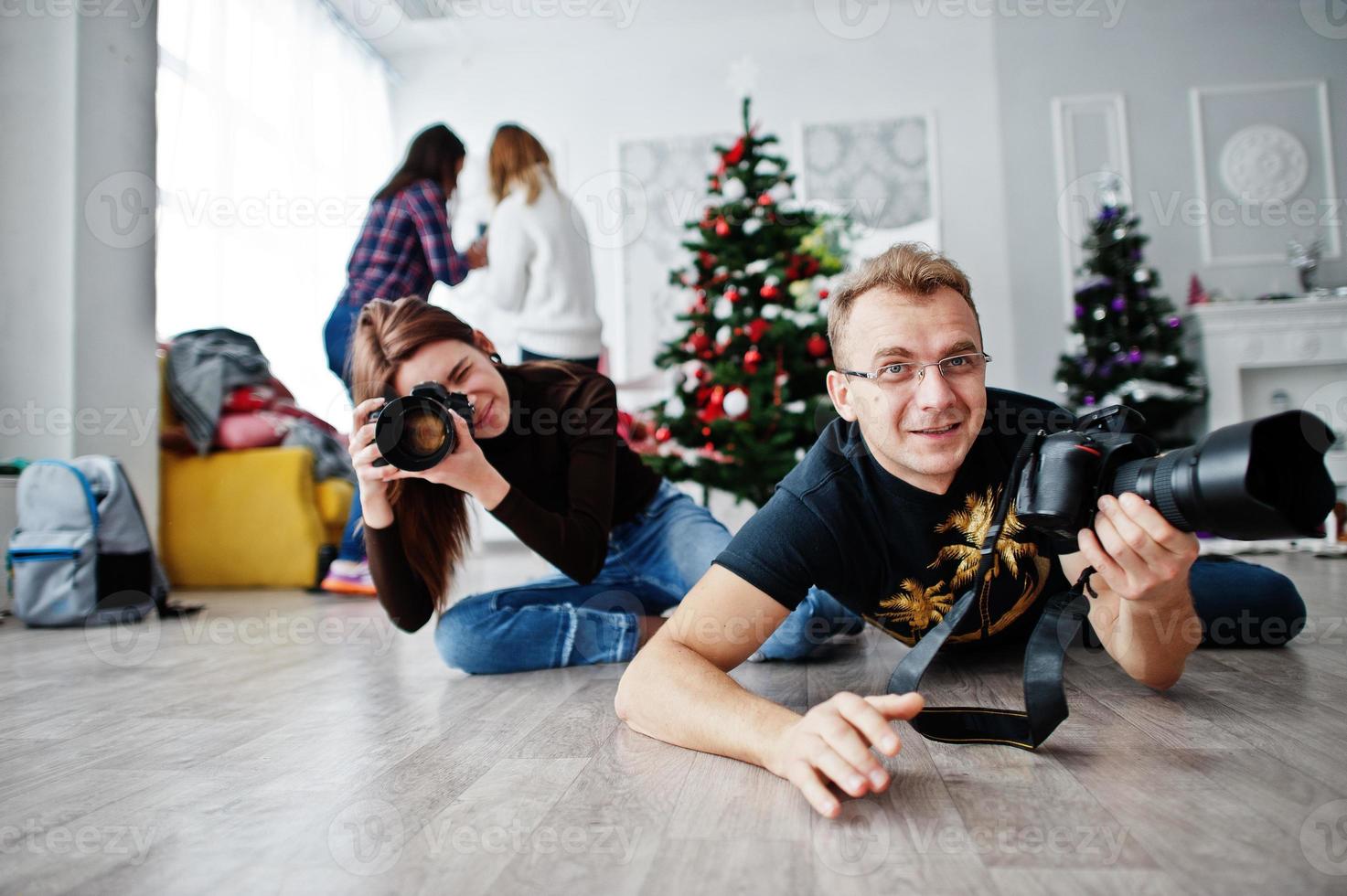 The team of two photographers lie on the floor and shooting on studio. photo