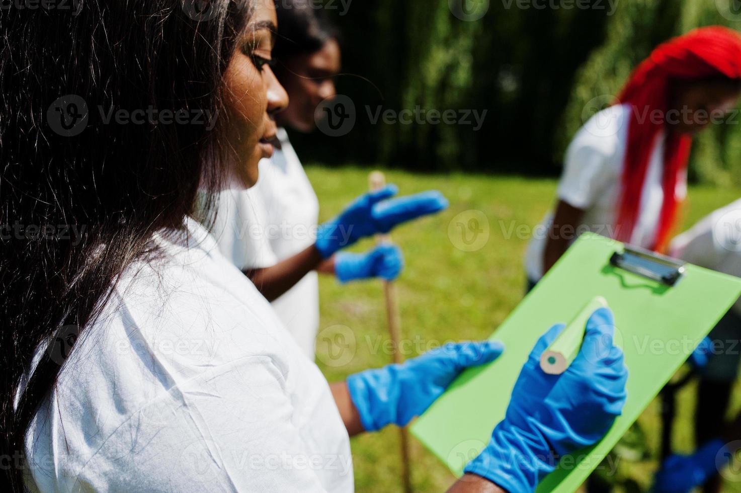 Happy african volunteer woman hold clipboard. Africa volunteering, charity, people and ecology concept. photo