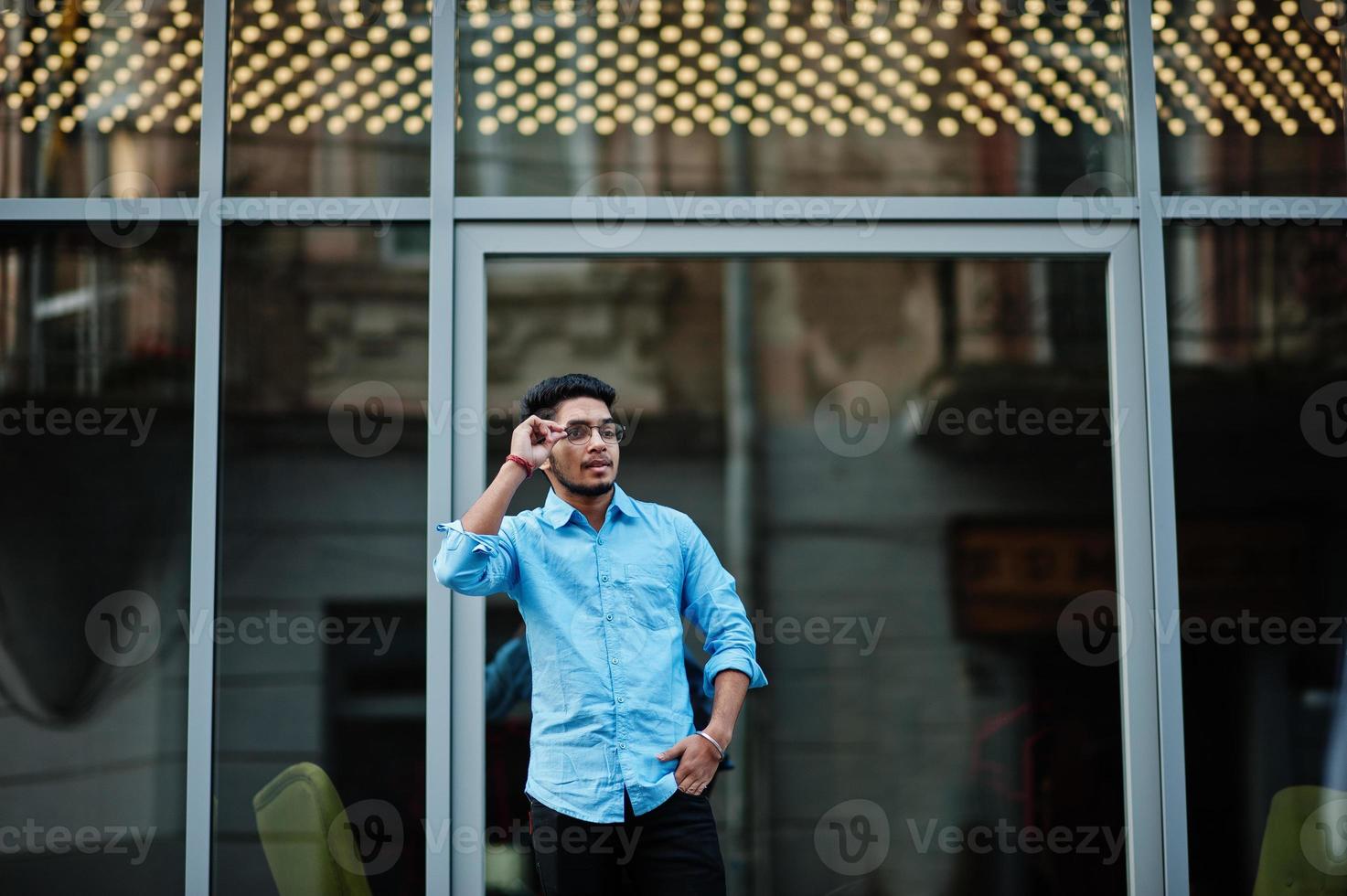 South asian indian male student wear eyeglasses and casual posed outdoor. photo