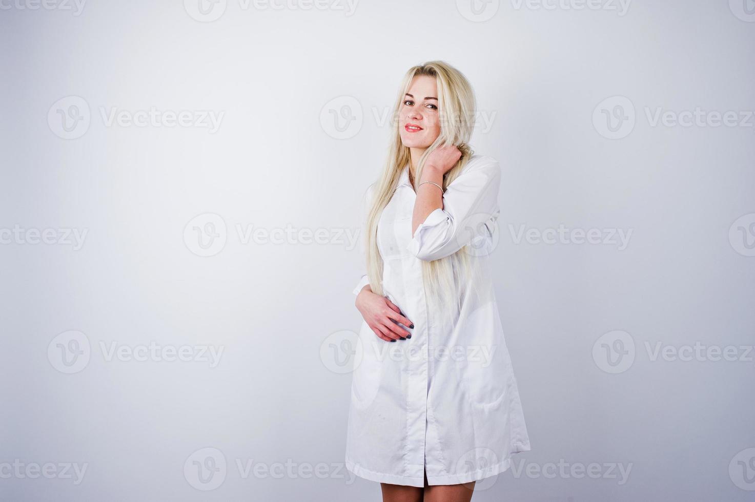 atractiva rubia doctora o enfermera en bata de laboratorio aislada en fondo blanco. foto