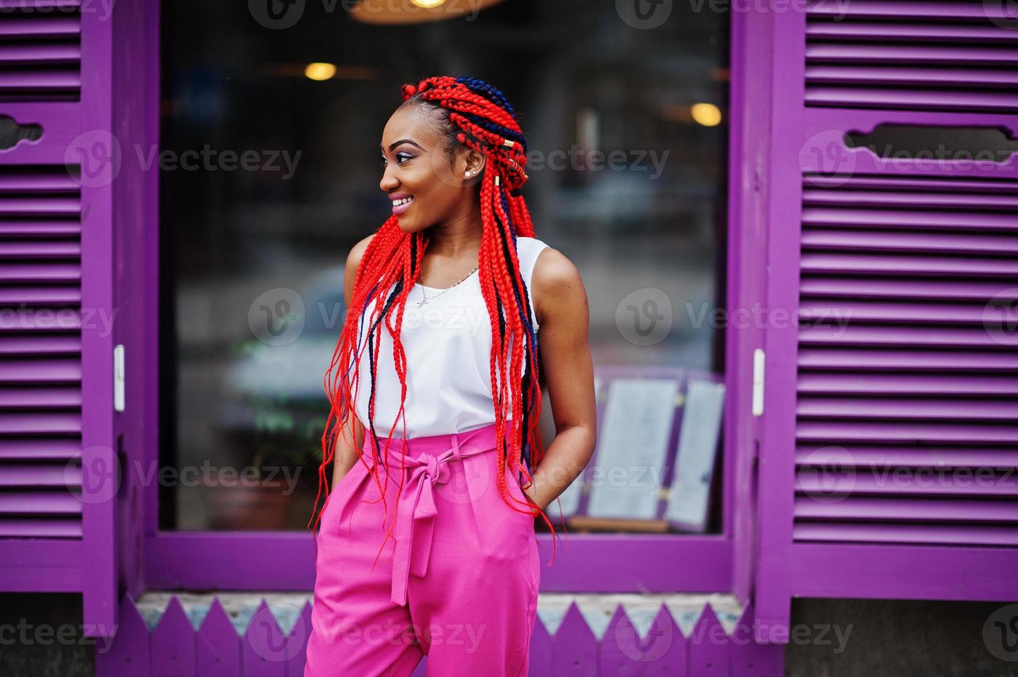 Fashionable african american girl at pink pants and red dreads posed outdoor. photo