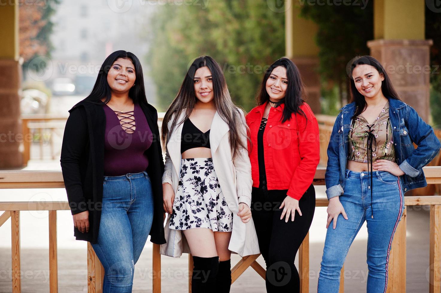 Group of four happy and pretty latino girls from Ecuador posed at street. photo