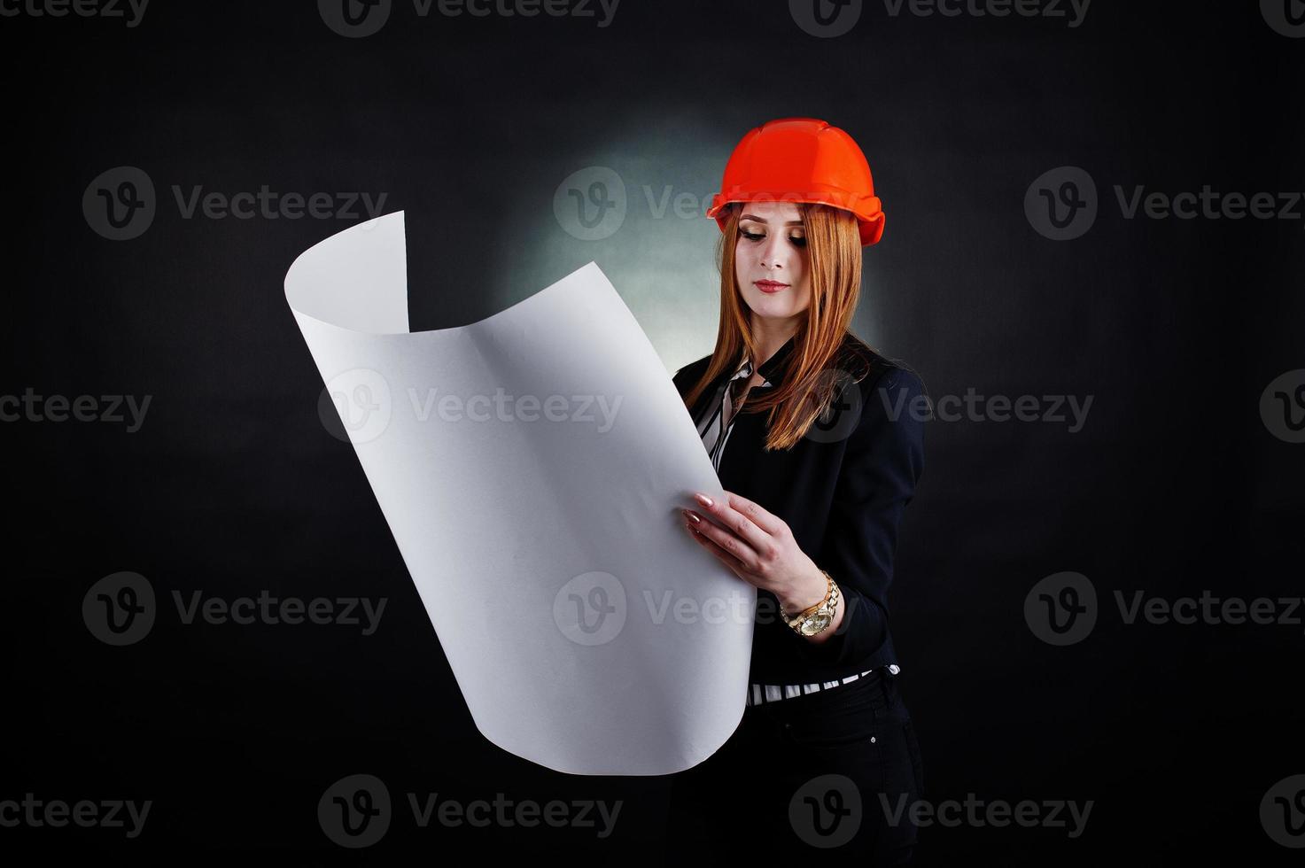 mujer ingeniera en casco de protección naranja con proyecto de papel de construcción. foto