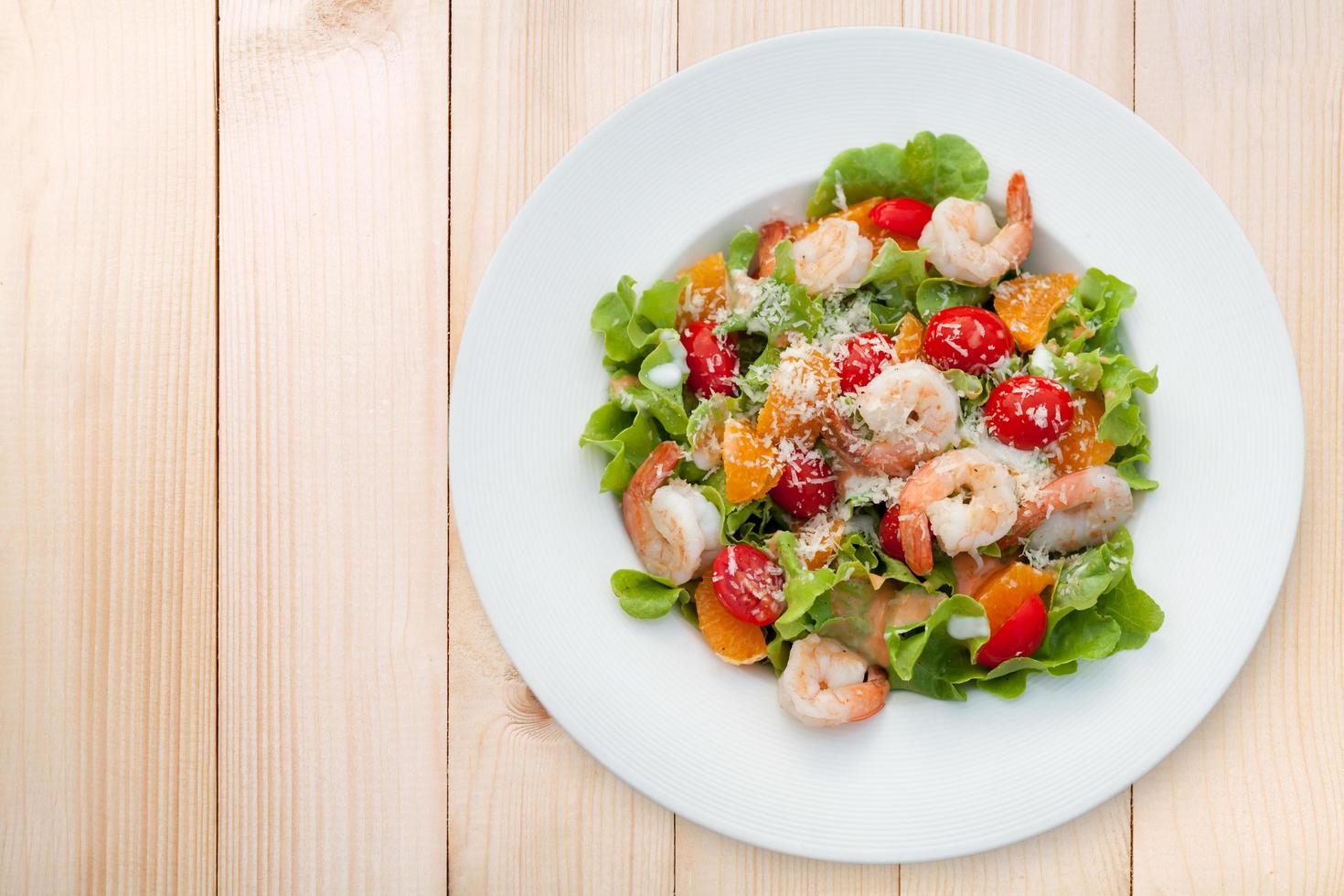 Grilled shrimp salad on wood table, Top view photo