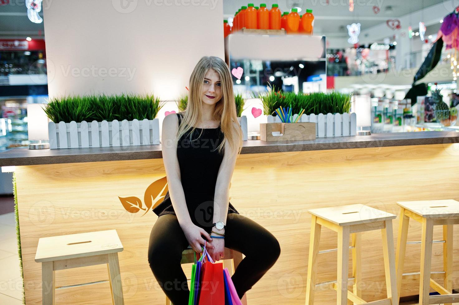 Girl with shopping bags in the mall sitting chair. photo