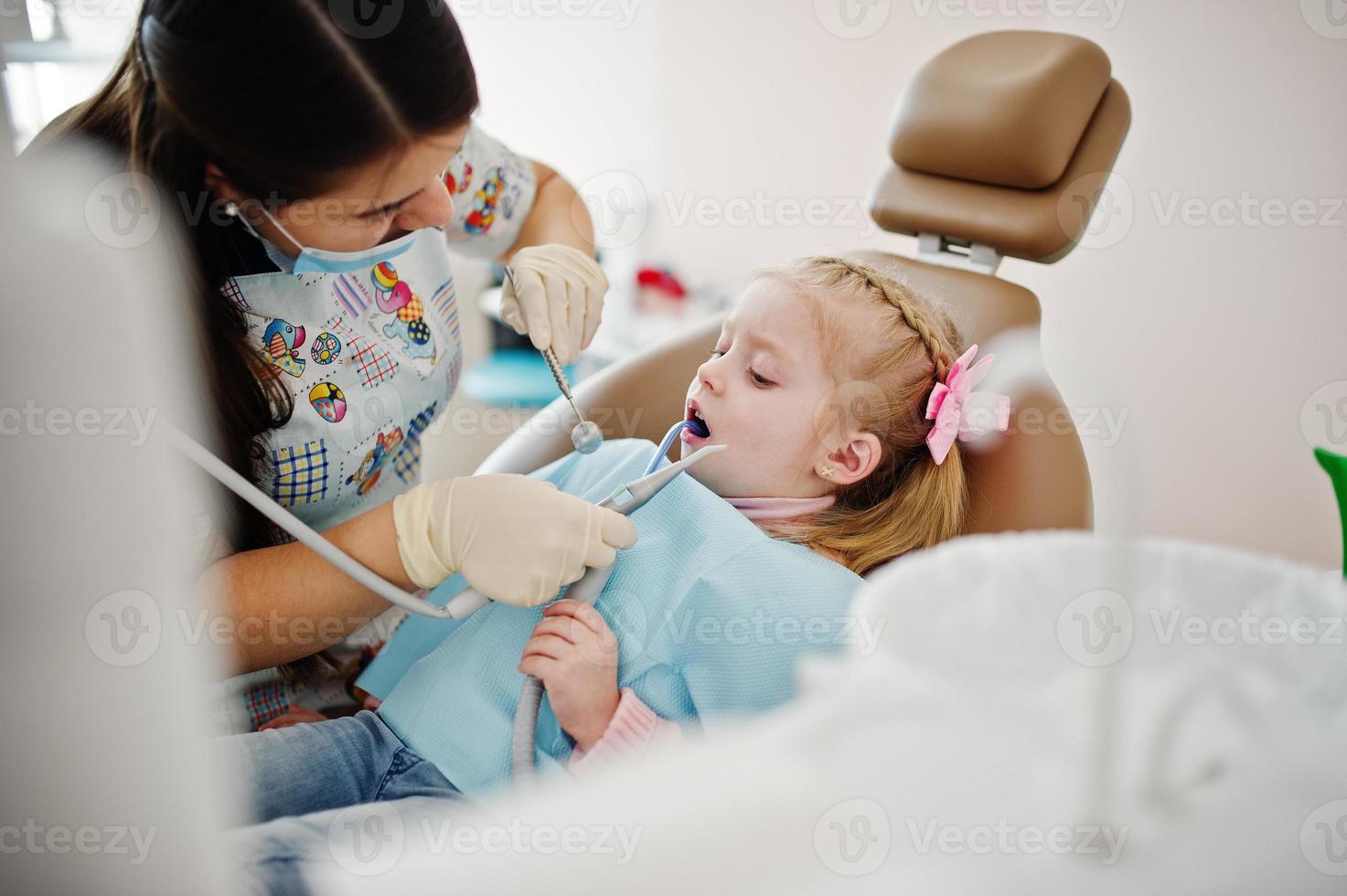 hijita en la silla del dentista. niños dentales. foto