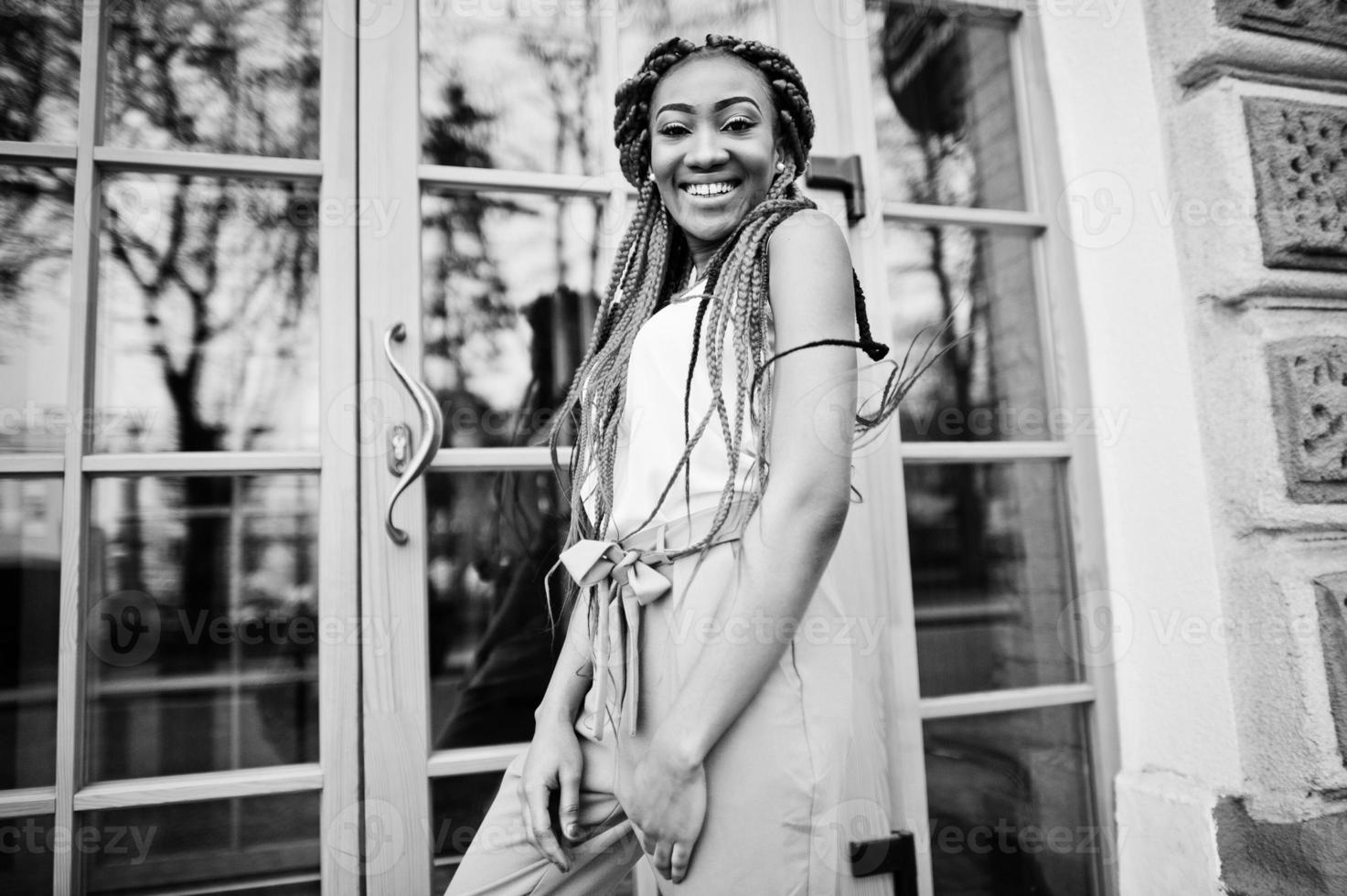 chica afroamericana de moda en pantalones rosas y rastas rojas posadas al aire libre. foto