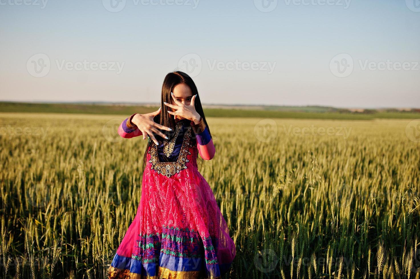 Tender indian girl in saree, with violet lips make up posed at field in sunset. Fashionable india model. photo