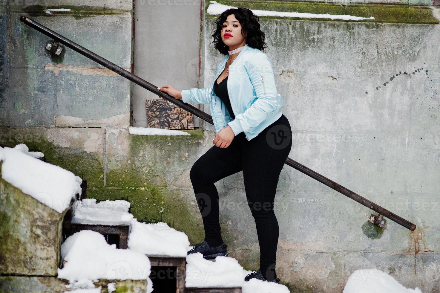 Stylish african american plus size model at streets of city on winter day. photo