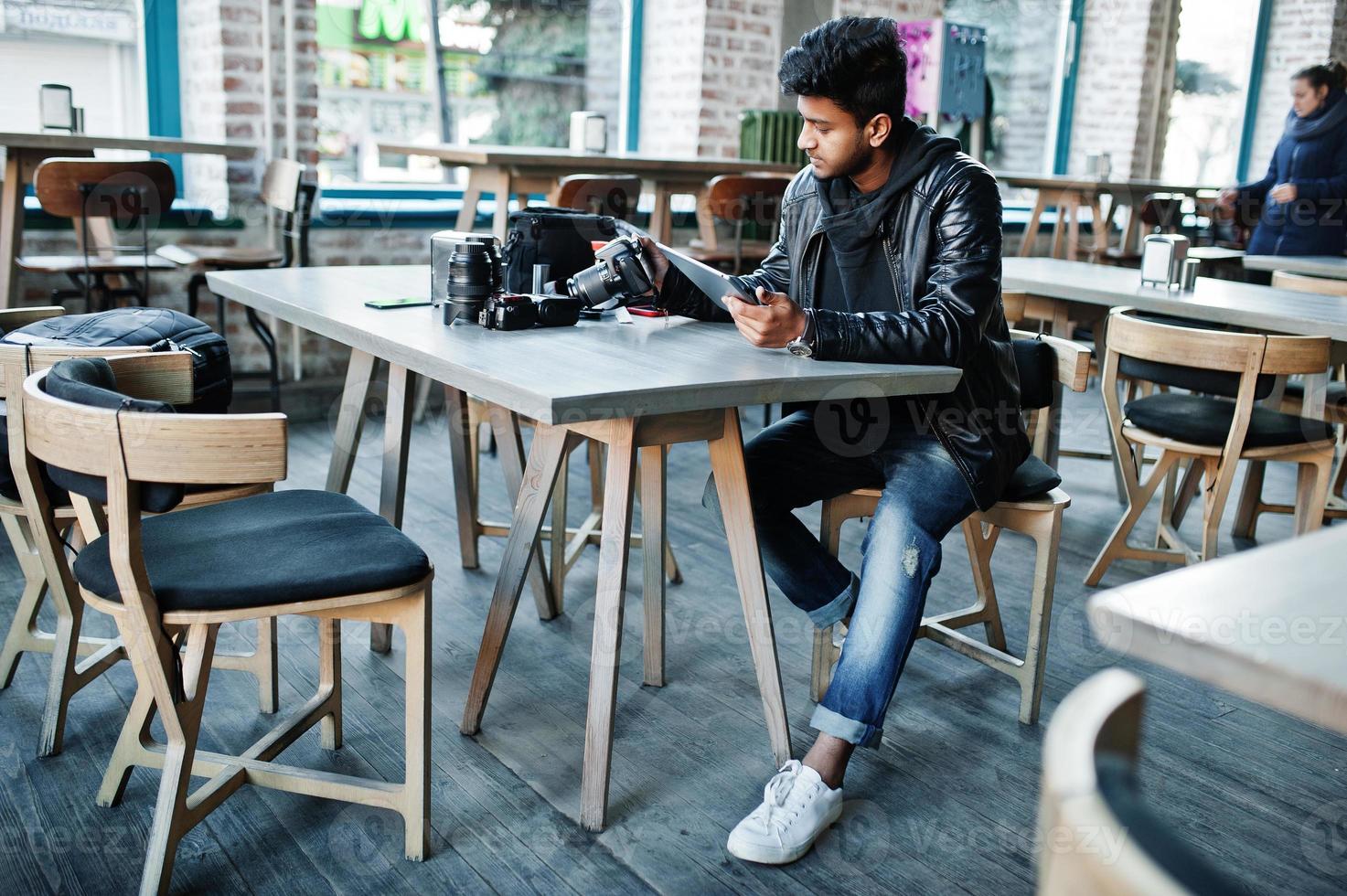 Smart young asian man photographer working with tablet during sitting at cafe. photo