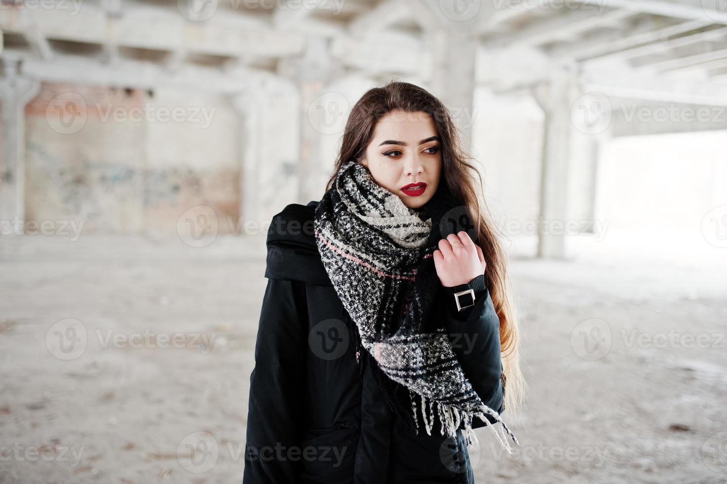 chica casual con estilo morena en bufanda contra el lugar de la fábrica abandonada. foto