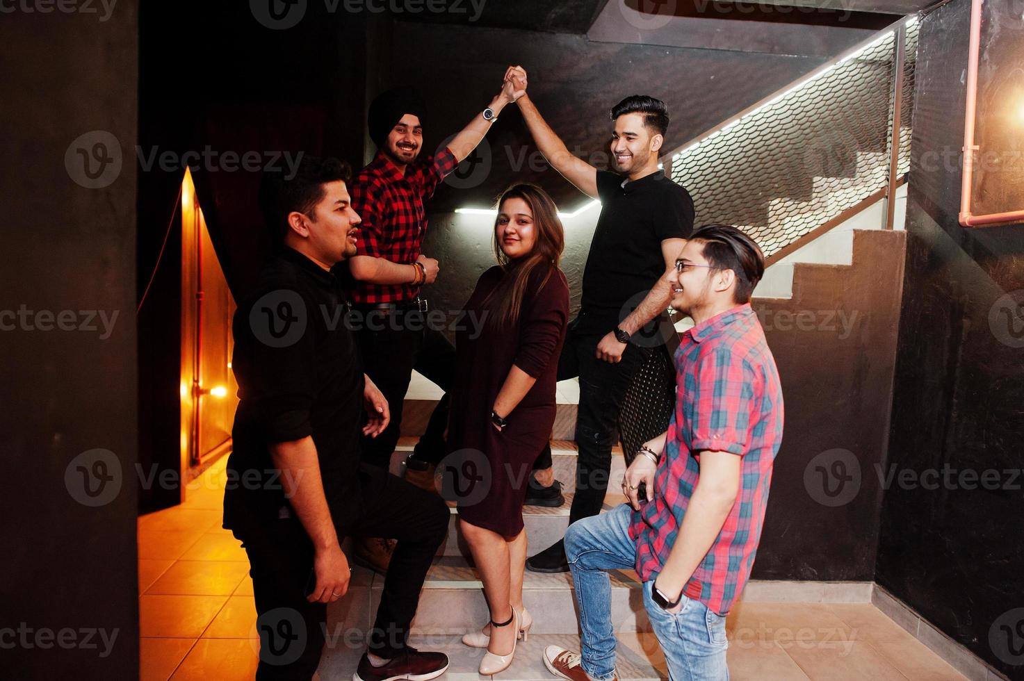 Group of indian friends having fun and rest at night club. photo
