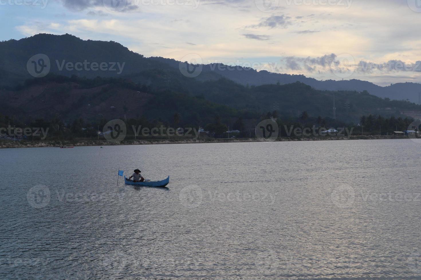 silueta de pescador en su barco foto