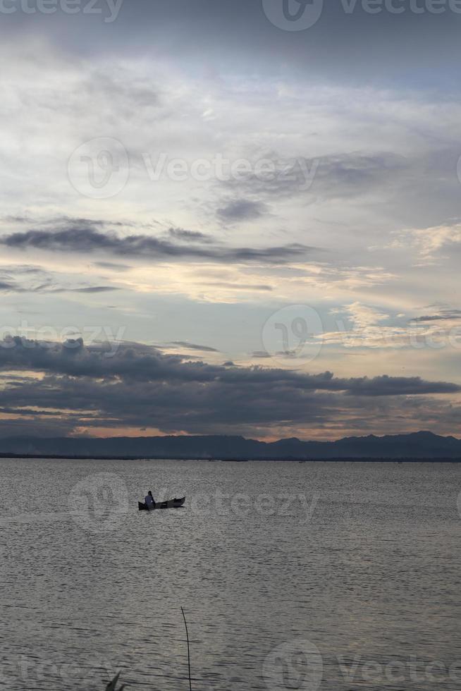 silueta de pescador en su barco foto