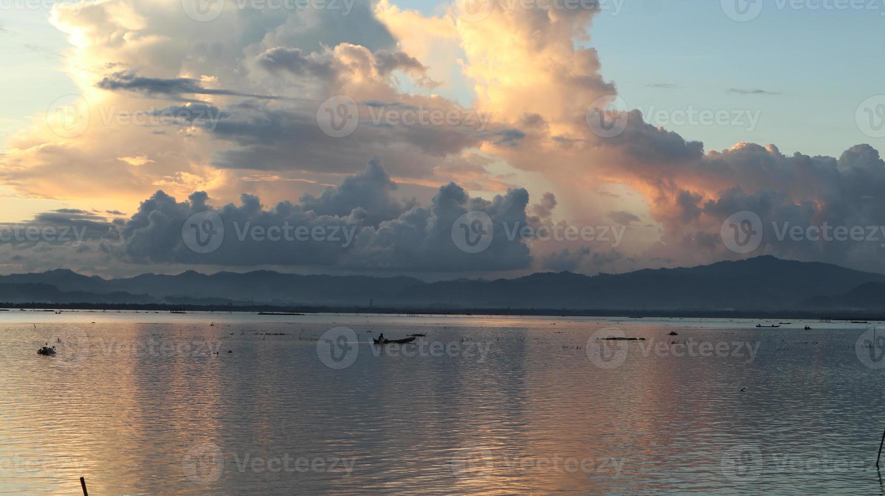 pescador en su barco al atardecer. barco de pescadores al atardecer foto