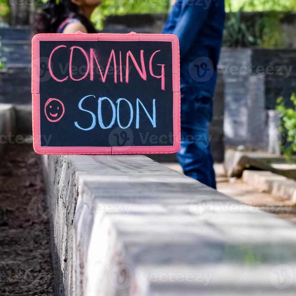 Indian couple posing for maternity baby shoot. The couple is posing in a lawn with green grass and the woman is falunting her baby bump in Lodhi Garden in New Delhi, India photo