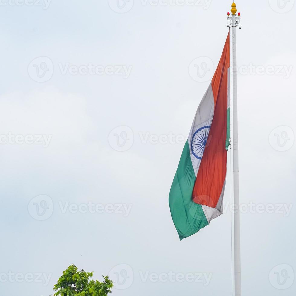 India flag flying high at Connaught Place with pride in blue sky, India flag fluttering, Indian Flag on Independence Day and Republic Day of India, tilt up shot, Waving Indian flag, Har Ghar Tiranga photo