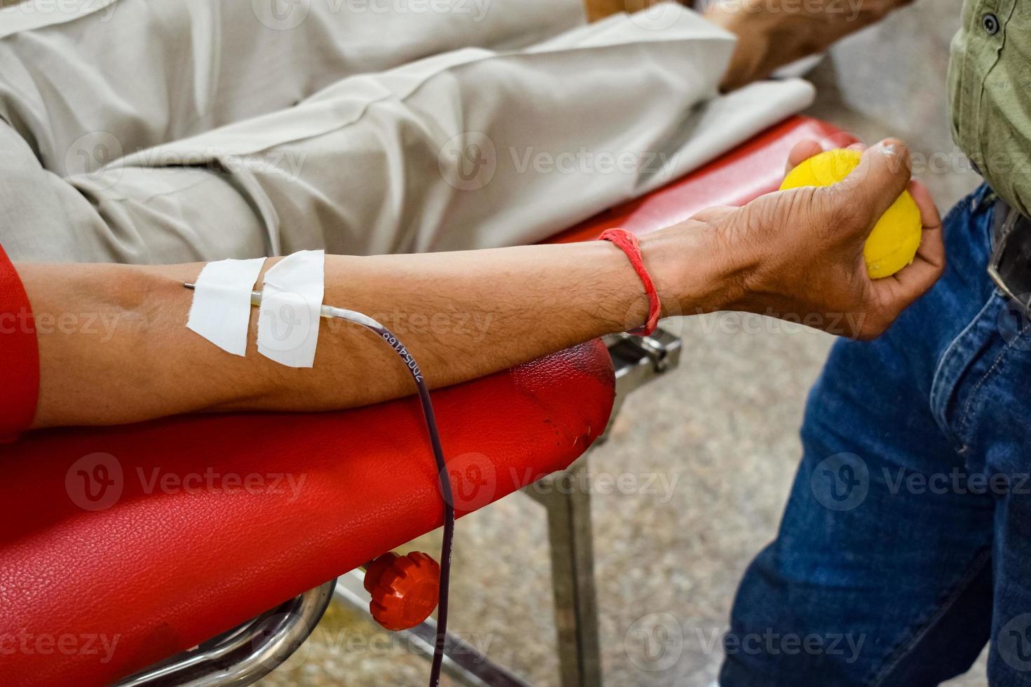 donante de sangre en el campamento de donación de sangre sostenido con una pelota hinchable en la mano en el templo balaji, vivek vihar, delhi, india, imagen para el día mundial del donante de sangre el 14 de junio de cada año, campamento de donación de sangre foto