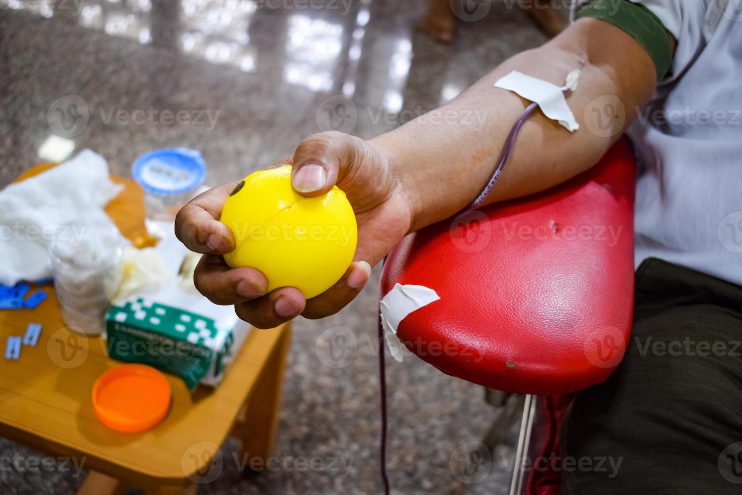 Blood donor at Blood donation camp held with a bouncy ball holding in hand at Balaji Temple, Vivek Vihar, Delhi, India, Image for World blood donor day on June 14 every year, Blood Donation Camp photo