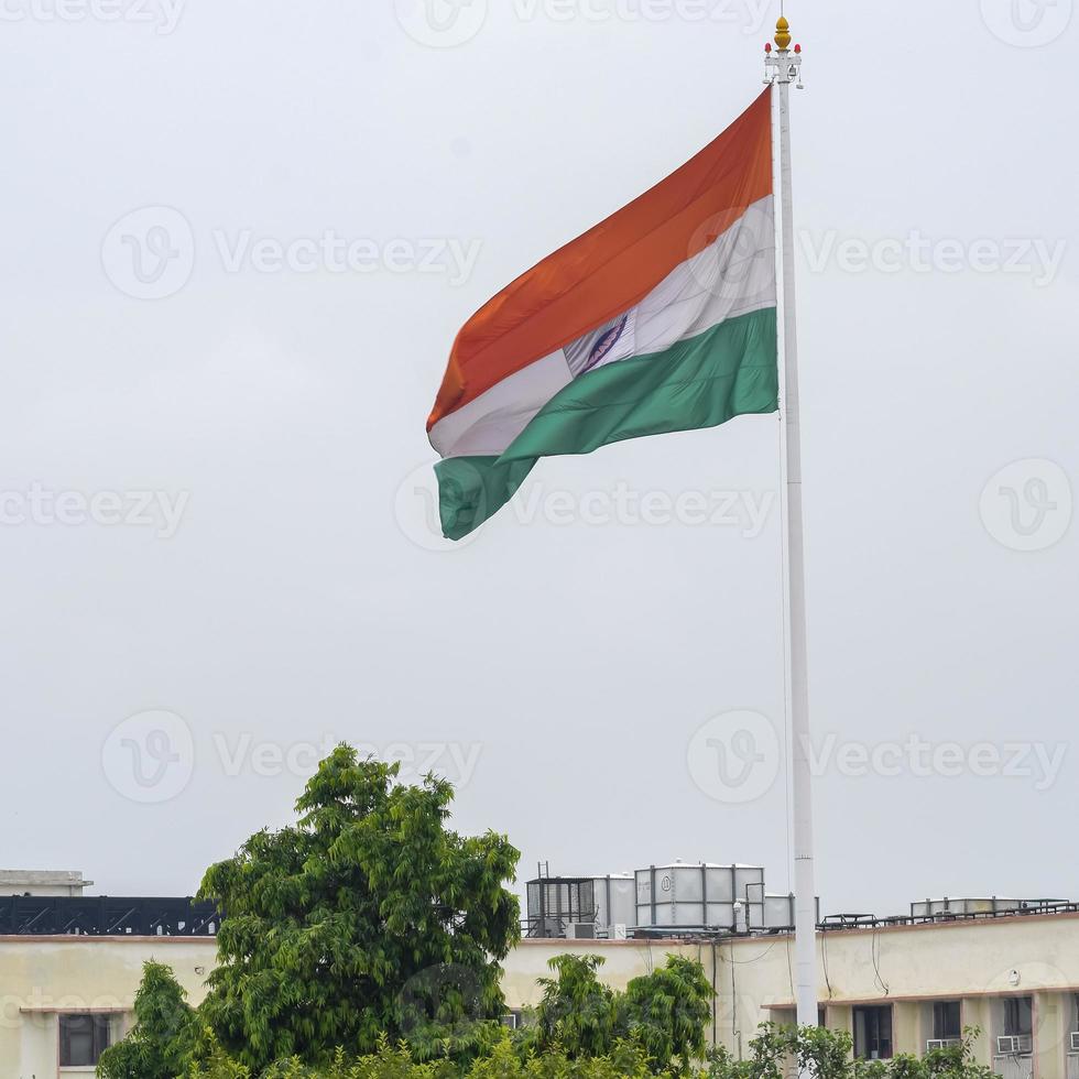 India flag flying high at Connaught Place with pride in blue sky, India flag fluttering, Indian Flag on Independence Day and Republic Day of India, tilt up shot, Waving Indian flag, Har Ghar Tiranga photo