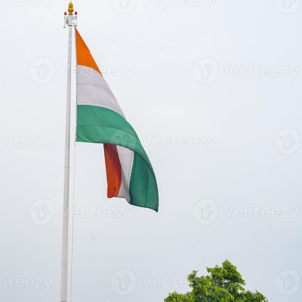 India flag flying high at Connaught Place with pride in blue sky, India flag fluttering, Indian Flag on Independence Day and Republic Day of India, tilt up shot, Waving Indian flag, Har Ghar Tiranga photo