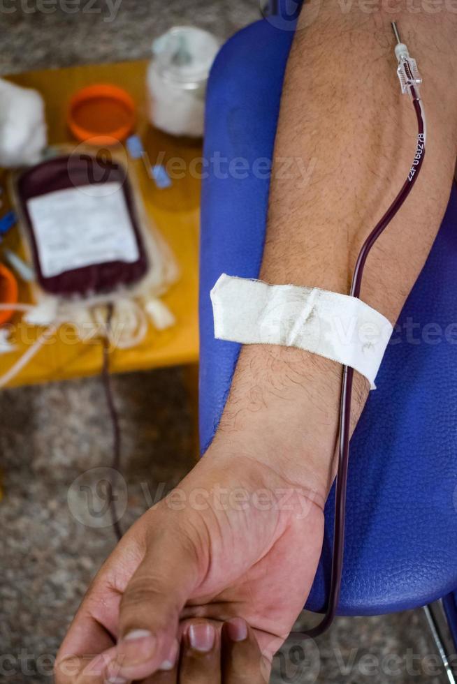 Blood donor at Blood donation camp held with a bouncy ball holding in hand at Balaji Temple, Vivek Vihar, Delhi, India, Image for World blood donor day on June 14 every year, Blood Donation Camp photo