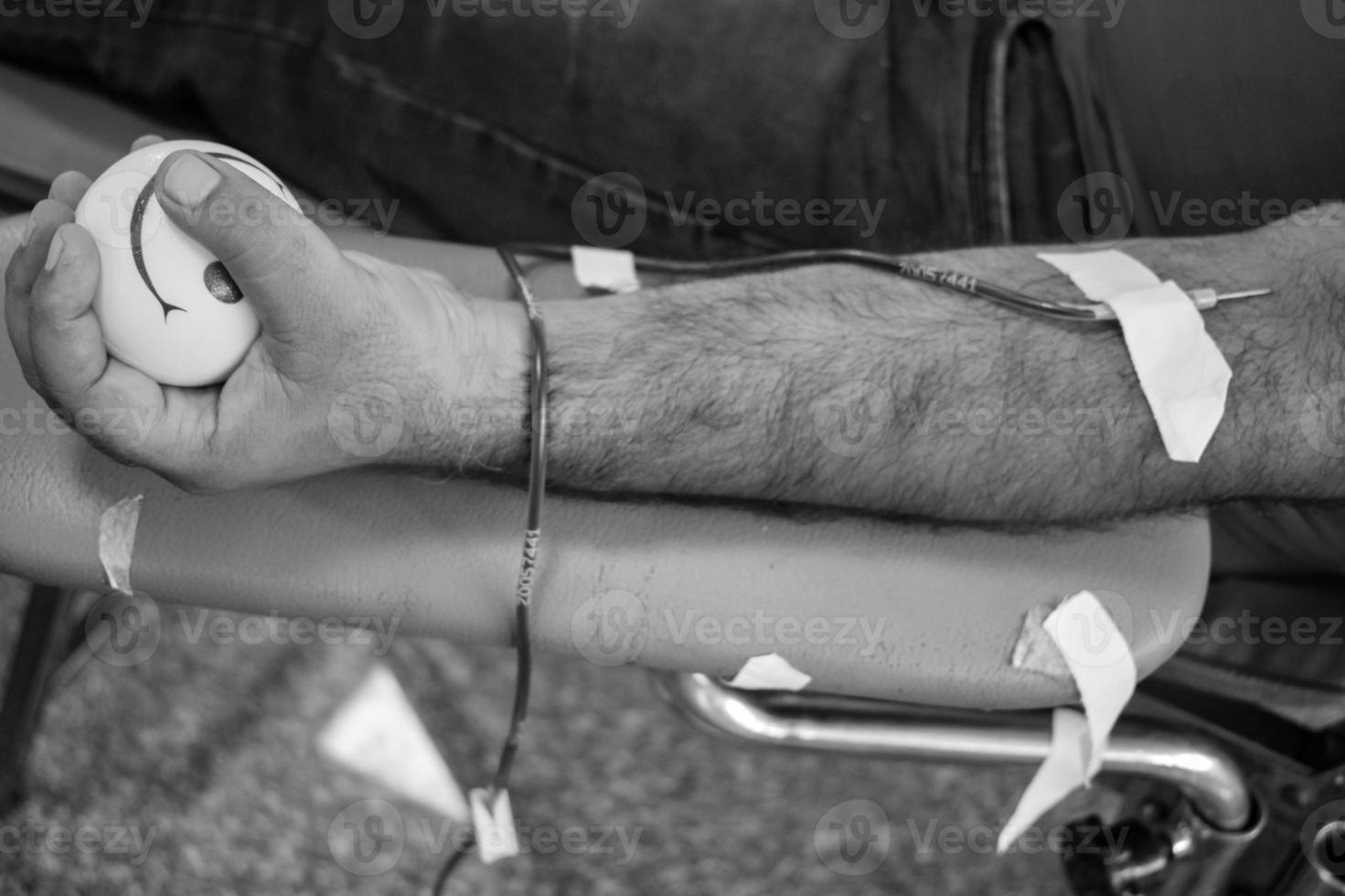 Blood donor at Blood donation camp held with a bouncy ball holding in hand at Balaji Temple, Vivek Vihar, Delhi, India, Image for World blood donor day on June 14 every year, Blood Donation Camp photo