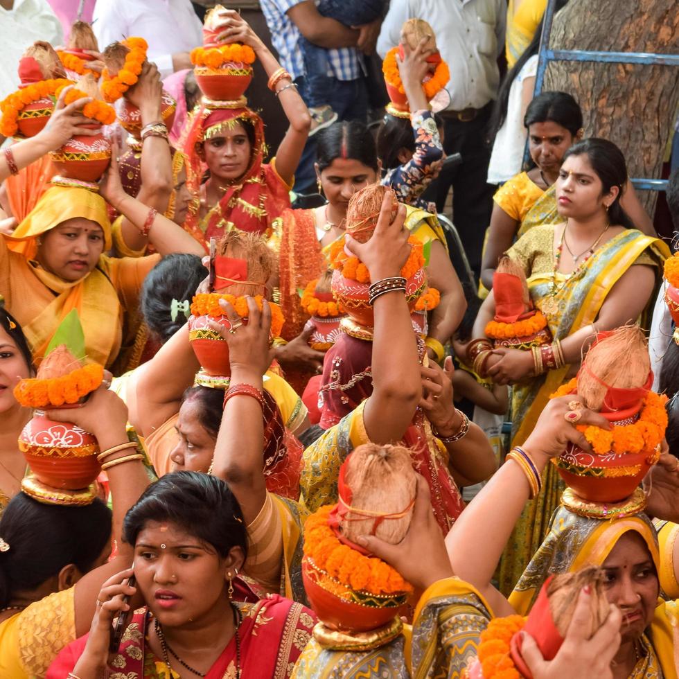 New Delhi, India April 03 2022 - Women with Kalash on head during Jagannath Temple Mangal Kalash Yatra, Indian Hindu devotees carry earthen pots containing sacred water with a coconut on top photo