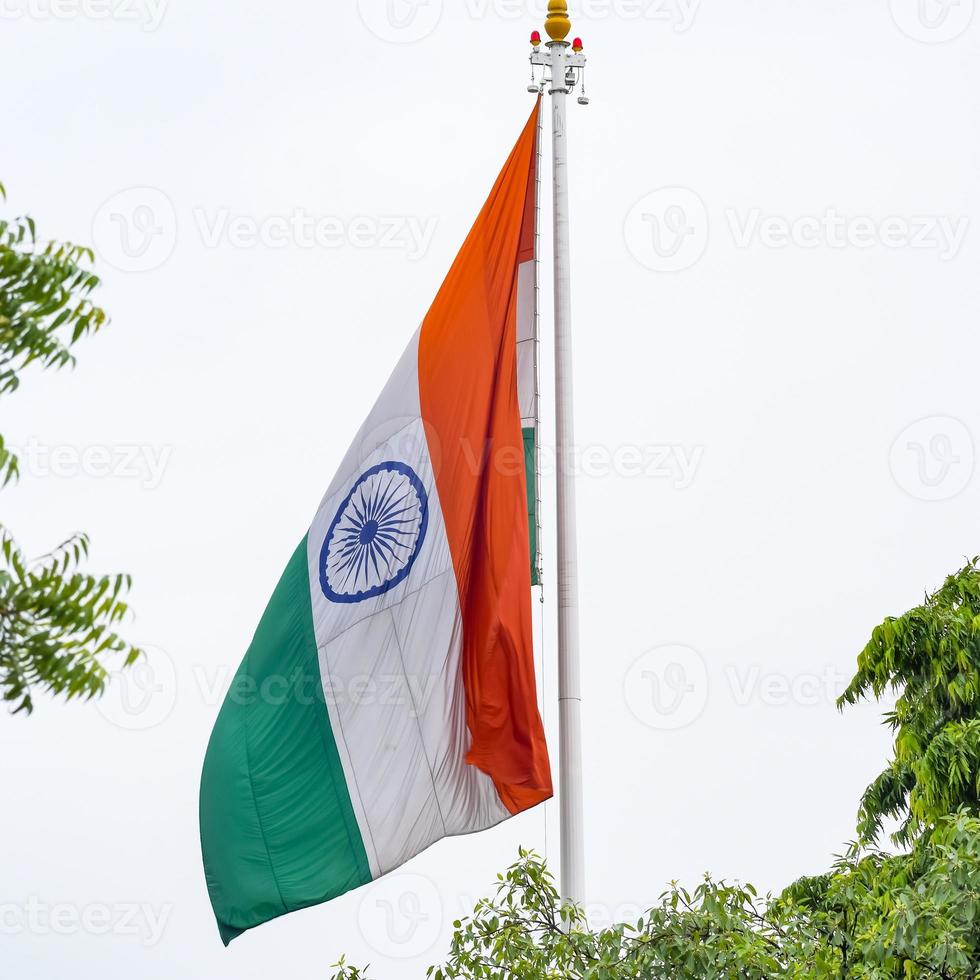 India flag flying high at Connaught Place with pride in blue sky, India flag fluttering, Indian Flag on Independence Day and Republic Day of India, tilt up shot, Waving Indian flag, Har Ghar Tiranga photo