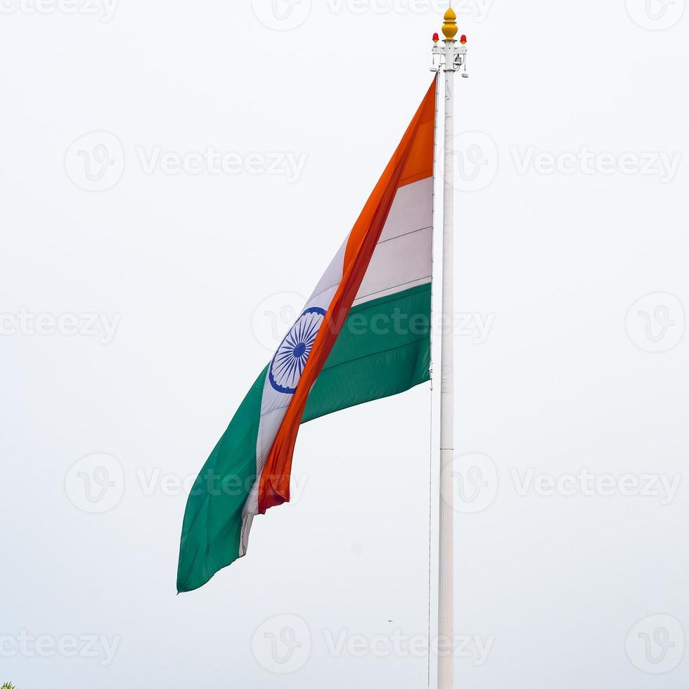 India flag flying high at Connaught Place with pride in blue sky, India flag fluttering, Indian Flag on Independence Day and Republic Day of India, tilt up shot, Waving Indian flag, Har Ghar Tiranga photo