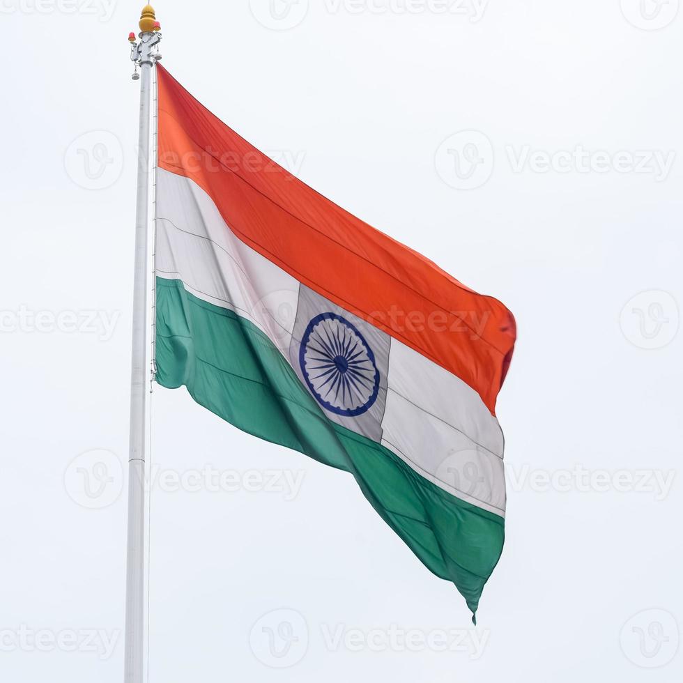 India flag flying high at Connaught Place with pride in blue sky, India flag fluttering, Indian Flag on Independence Day and Republic Day of India, tilt up shot, Waving Indian flag, Har Ghar Tiranga photo
