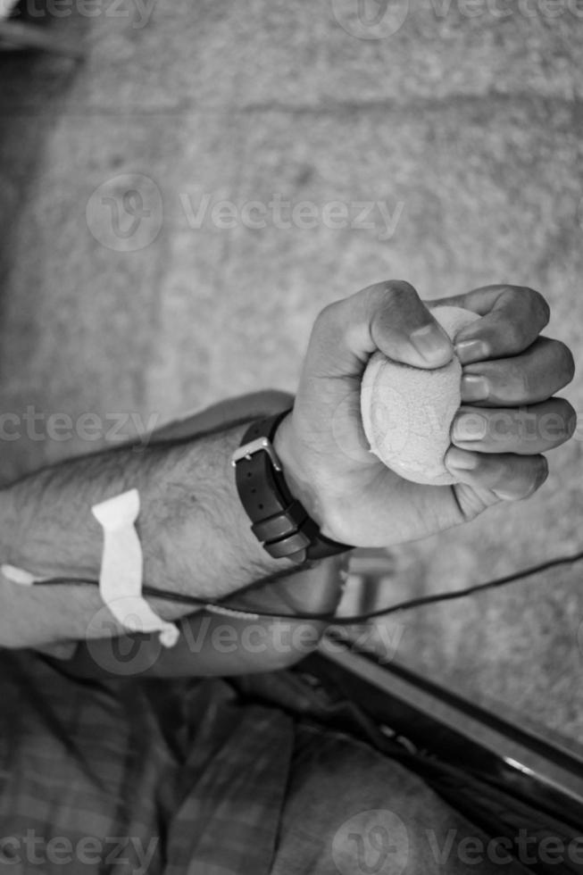 Blood donor at Blood donation camp held with a bouncy ball holding in hand at Balaji Temple, Vivek Vihar, Delhi, India, Image for World blood donor day on June 14 every year, Blood Donation Camp photo