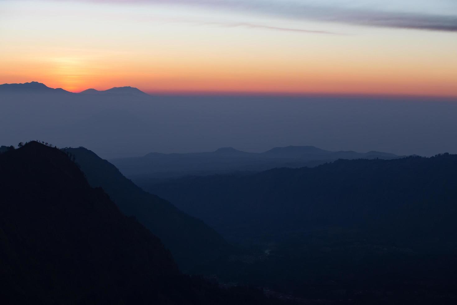 Foggy and volcano mountain during sunrise taken from Pinajagun II view point ,Indonesia photo